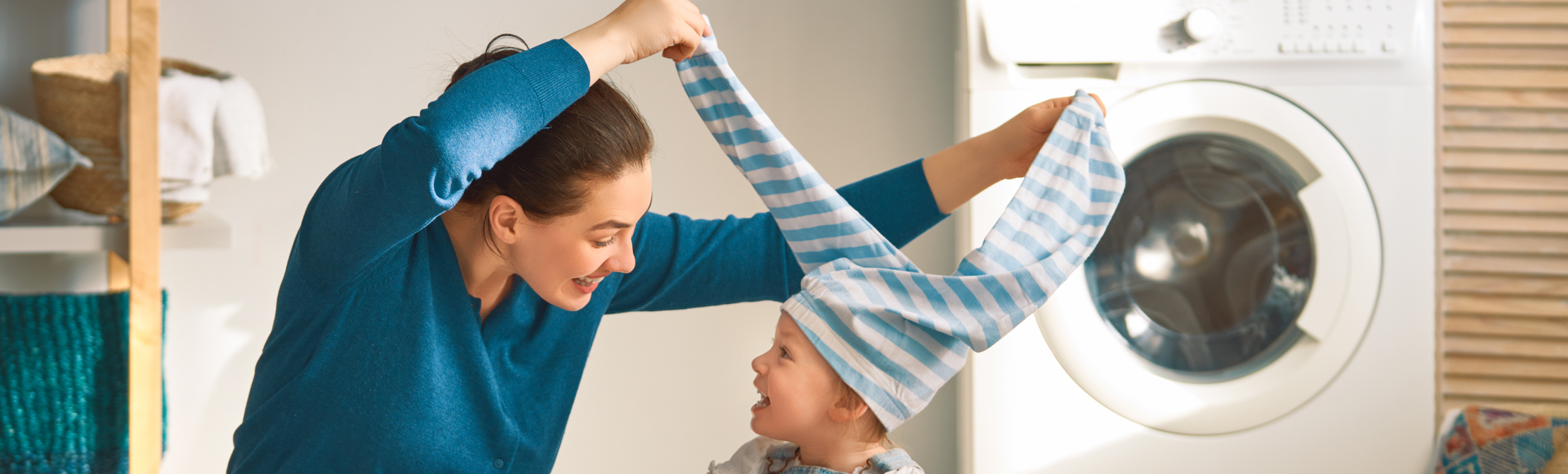 Woman and child playing in laundry room.