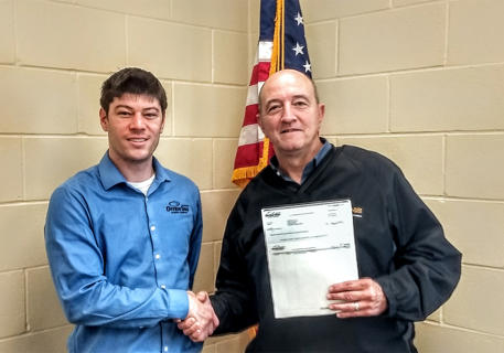 Photo caption: Garton (left) presents a rebate check to Ulen-Hitterdal Public School Superintendent Todd Cameron.
