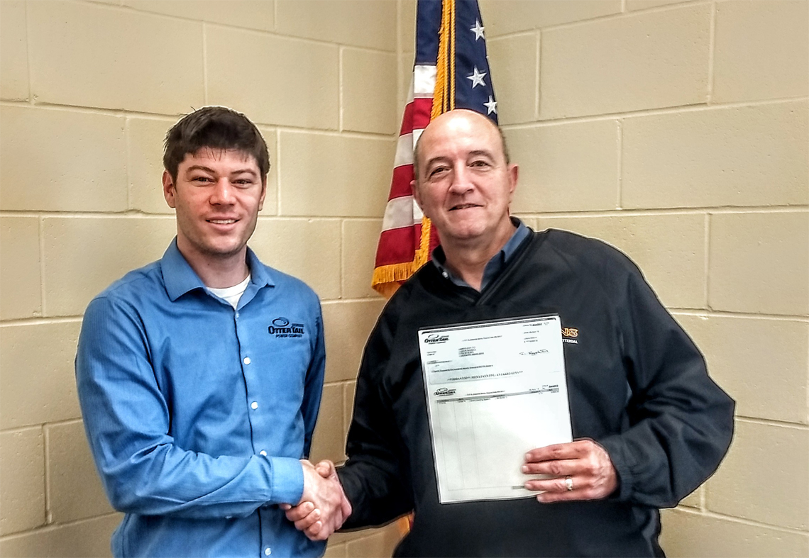 Photo caption: Garton (left) presents a rebate check to Ulen-Hitterdal Public School Superintendent Todd Cameron.